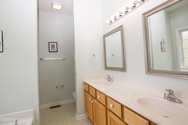 bathroom with a sink, visible vents, toilet, and double vanity
