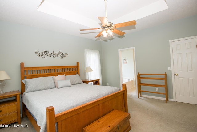 bedroom featuring ceiling fan, light colored carpet, and ensuite bath