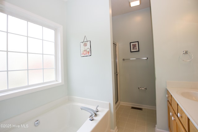 bathroom with vanity, tile patterned floors, visible vents, a bath, and a shower with shower door