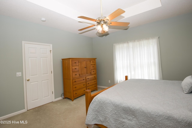 bedroom featuring light colored carpet, baseboards, and ceiling fan