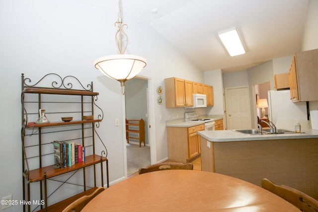 kitchen with vaulted ceiling, white appliances, light countertops, light colored carpet, and a sink
