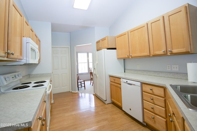 kitchen featuring white appliances, light wood-style flooring, light brown cabinetry, light countertops, and a sink