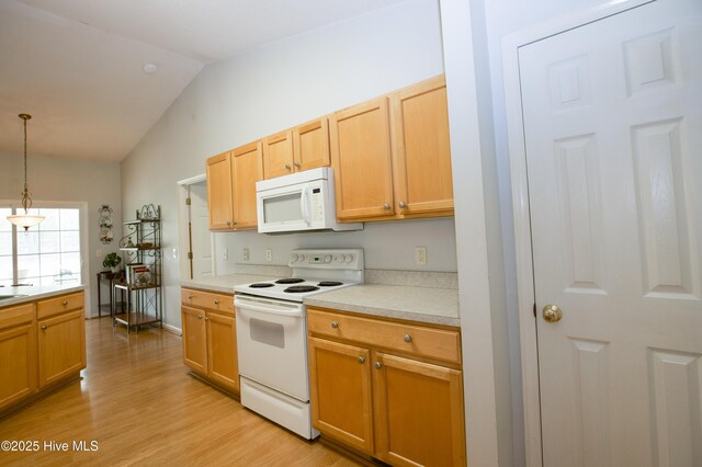 kitchen featuring vaulted ceiling, white appliances, light countertops, light wood finished floors, and hanging light fixtures