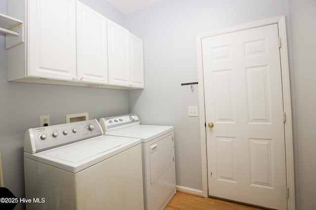laundry room with light wood-style floors, separate washer and dryer, baseboards, and cabinet space