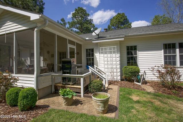 exterior space featuring a shingled roof and a sunroom