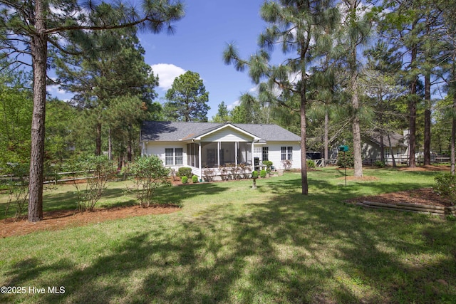 ranch-style house with fence, a front yard, roof with shingles, and a sunroom
