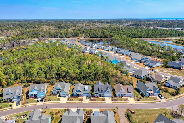 1381 Ellsworth Dr SW, Ocean Isle Beach, NC 28469 - aerial perspective of suburban area with a heavily wooded area and a nearby body of water