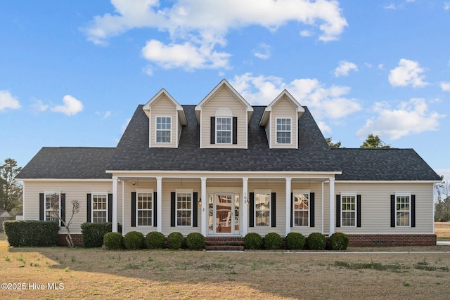 view of front of house featuring covered porch, a front yard, and a shingled roof