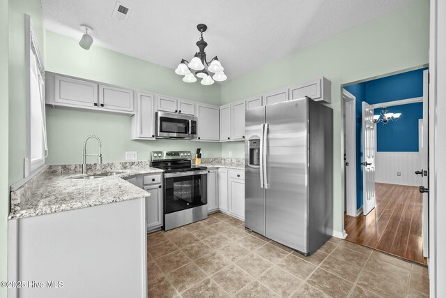 kitchen with a sink, appliances with stainless steel finishes, a chandelier, and visible vents