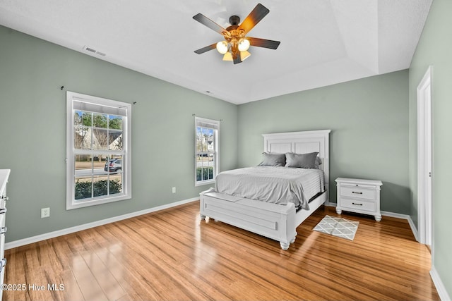 bedroom with baseboards, visible vents, wood finished floors, and a ceiling fan