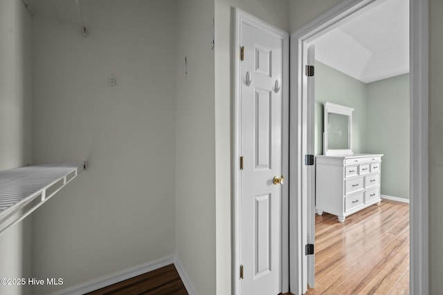 corridor with baseboards and light wood-style floors