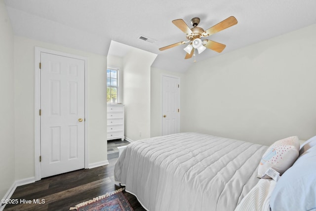 bedroom featuring baseboards, visible vents, a ceiling fan, and dark wood finished floors