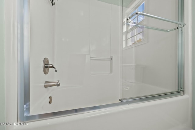 bathroom with shower / bath combination with glass door