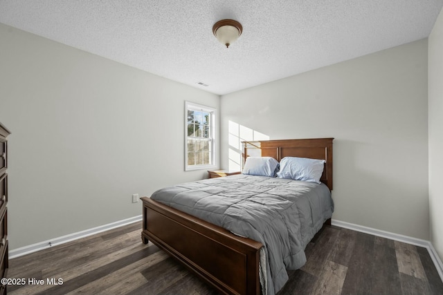 bedroom featuring baseboards, visible vents, and wood finished floors