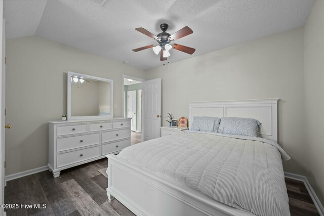 bedroom with baseboards, a textured ceiling, and dark wood-style flooring