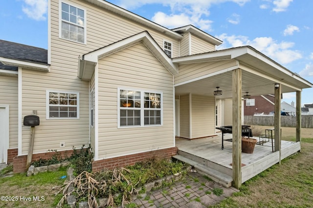 rear view of property with fence and a wooden deck