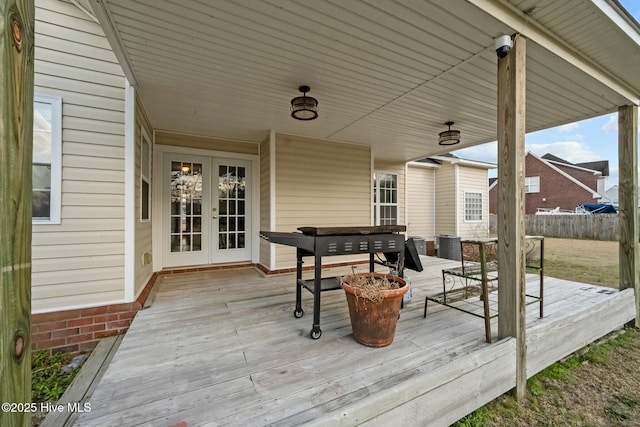deck featuring fence, outdoor dining area, and french doors