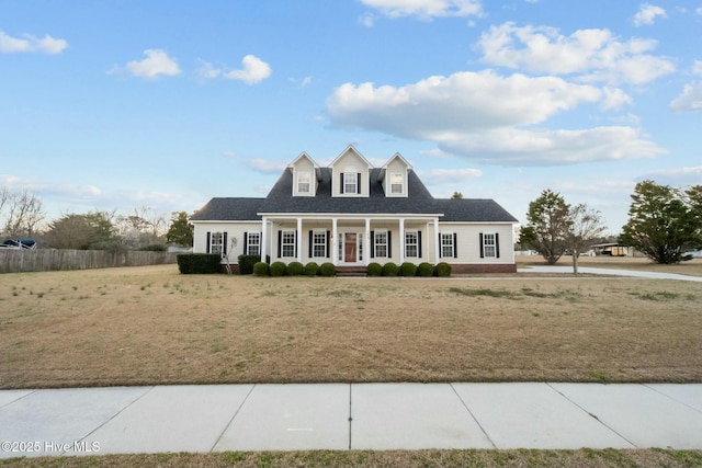 view of front of home with a front yard, a porch, and fence
