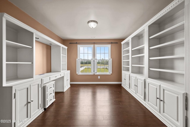 interior space featuring baseboards, dark wood-style floors, and built in desk