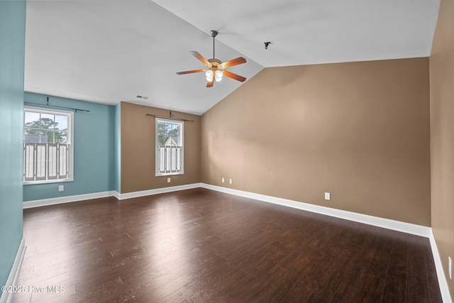 empty room featuring baseboards, ceiling fan, vaulted ceiling, and dark wood-style floors