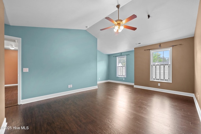 empty room with baseboards, ceiling fan, wood finished floors, and vaulted ceiling