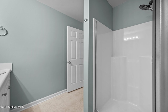 full bathroom with vanity, baseboards, and walk in shower