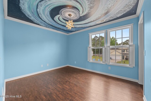 spare room featuring crown molding, dark wood finished floors, and baseboards