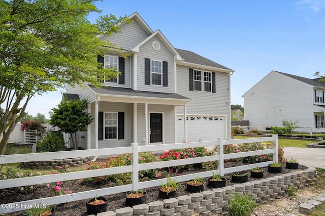 traditional-style house with a porch, fence, driveway, and a garage