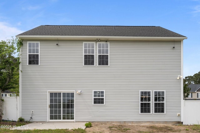 rear view of house featuring fence