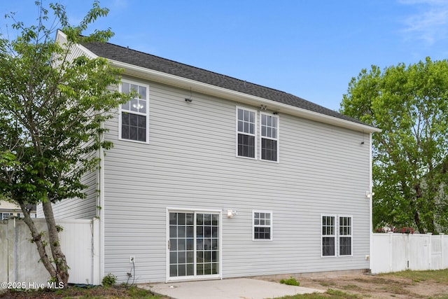 back of property with fence and a patio