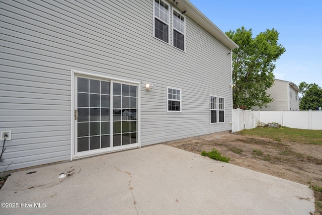 rear view of house featuring fence and a patio area