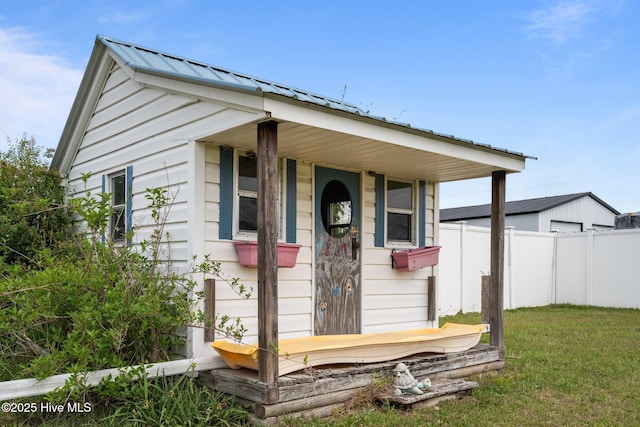 view of outbuilding with fence and an outbuilding