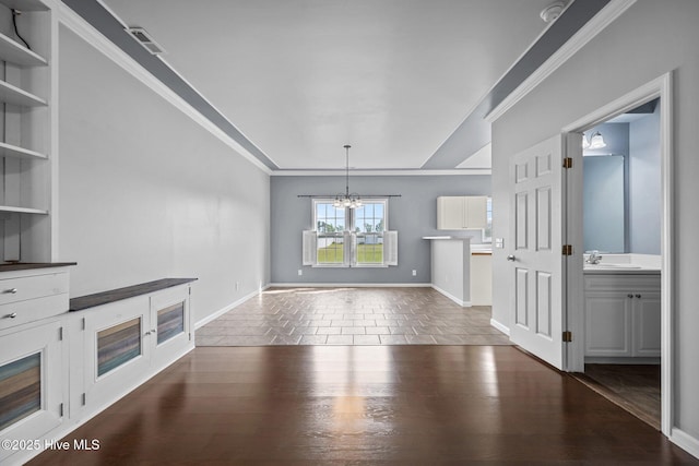 interior space featuring crown molding, baseboards, a sink, and a chandelier