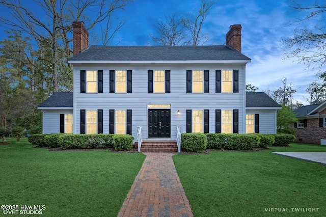 208 Elm St, Whiteville, NC 28472 - colonial house featuring a front yard, roof with shingles, and a chimney