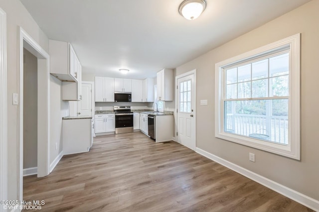 208 Elm St, Whiteville, NC 28472 - kitchen with a sink, white cabinetry, light wood-type flooring, stainless steel appliances, and baseboards
