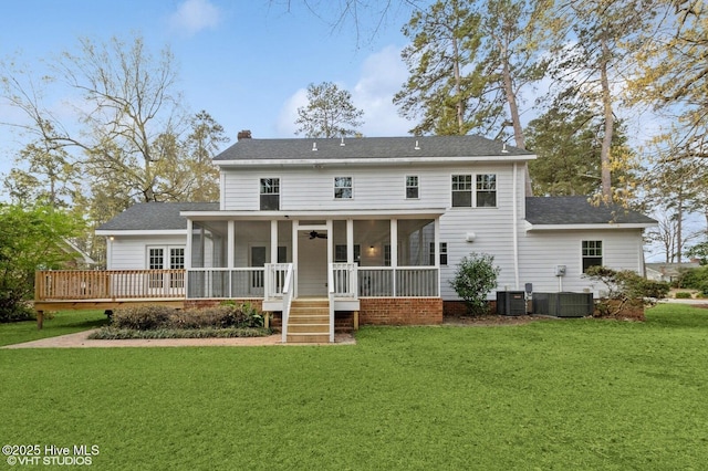 208 Elm St, Whiteville, NC 28472 - rear view of house featuring central air condition unit, a chimney, a shingled roof, a sunroom, and a lawn
