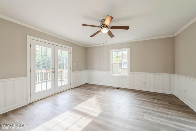 208 Elm St, Whiteville, NC 28472 - empty room featuring a wainscoted wall, french doors, wood finished floors, ceiling fan, and ornamental molding