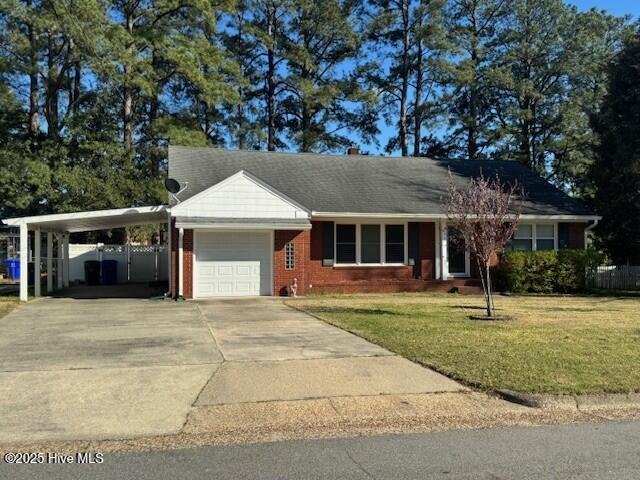 ranch-style house with concrete driveway, an attached garage, a front lawn, brick siding, and a carport