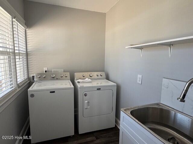 clothes washing area featuring separate washer and dryer, a sink, dark wood-style flooring, and laundry area