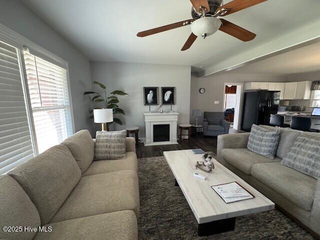 living room with dark wood-style floors, a fireplace, and ceiling fan