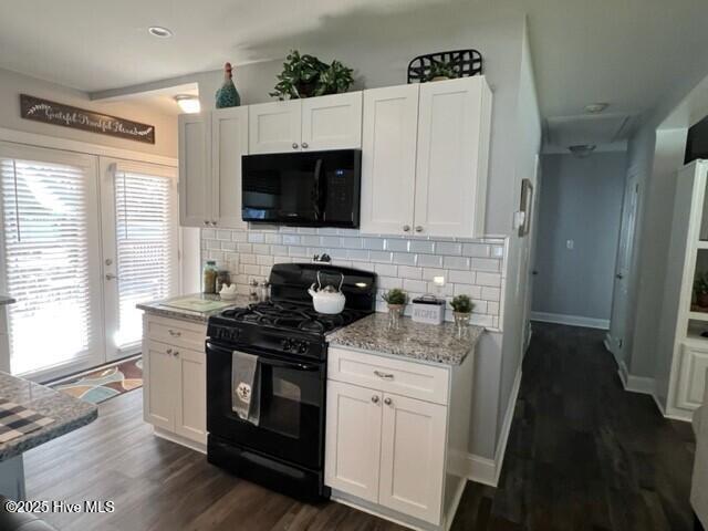 kitchen with backsplash, white cabinets, dark wood-style floors, and black appliances