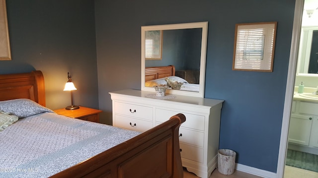 bedroom with a sink and connected bathroom