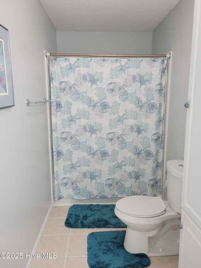 full bathroom featuring baseboards, tile patterned flooring, toilet, and a shower with shower curtain