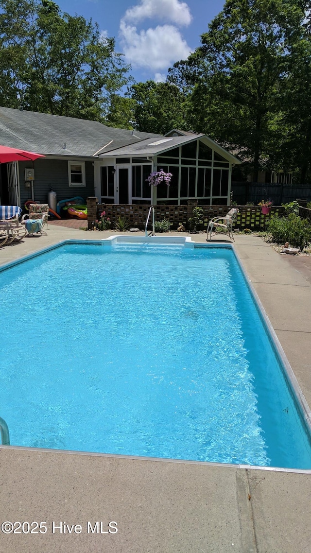 view of pool with a sunroom, fence, a fenced in pool, and a patio