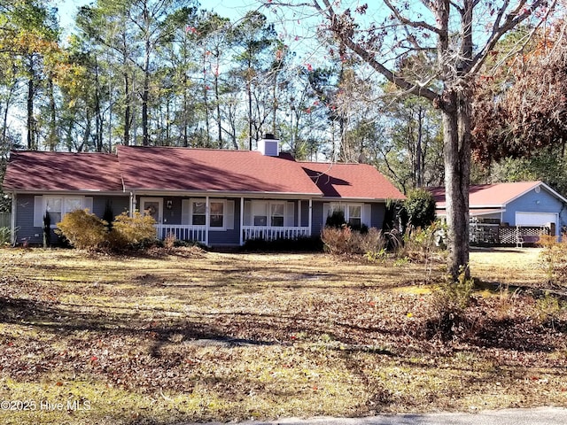 ranch-style house with a chimney and a porch