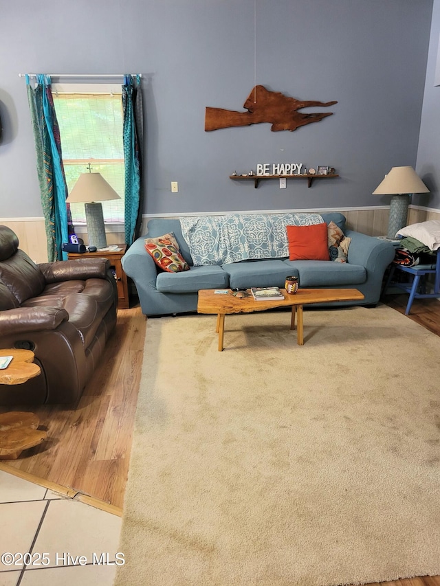 living room featuring wood finished floors and a wainscoted wall