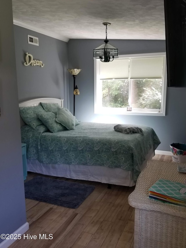 bedroom featuring visible vents and wood finished floors