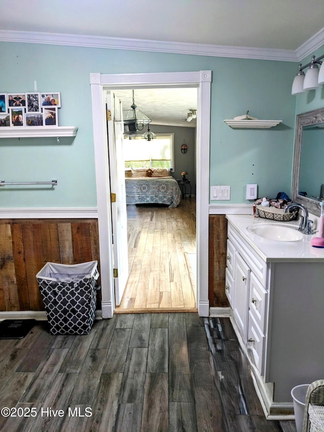 ensuite bathroom with vanity, ornamental molding, wood finished floors, and connected bathroom
