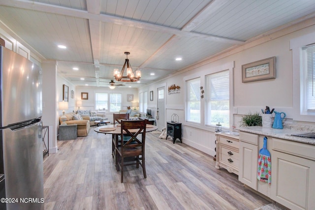 dining space featuring a wainscoted wall, wooden ceiling, beam ceiling, light wood-style flooring, and a notable chandelier