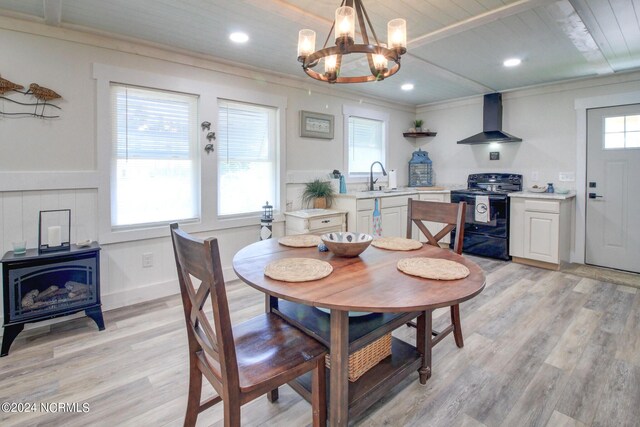 dining space featuring a notable chandelier, crown molding, light wood finished floors, and recessed lighting